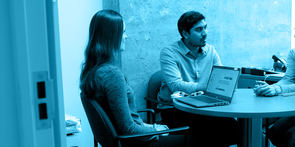 Associate Professor Sara Guilcher and graduate students meeting in office