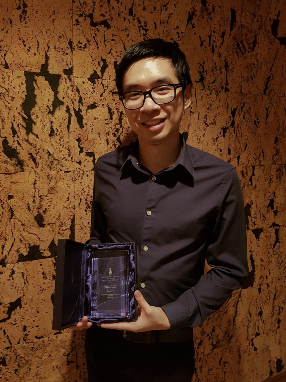Timothy Yu holding award
