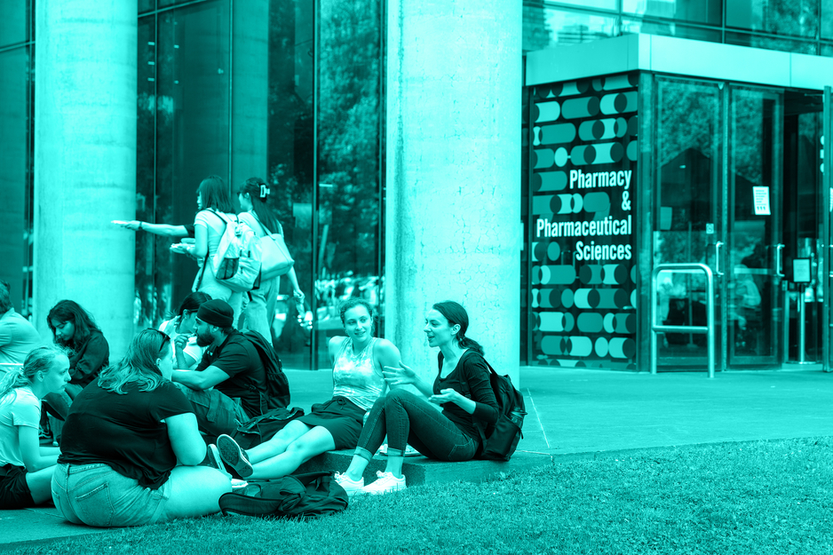 Pharmacy students sitting on steps out front of LDFP building entrance