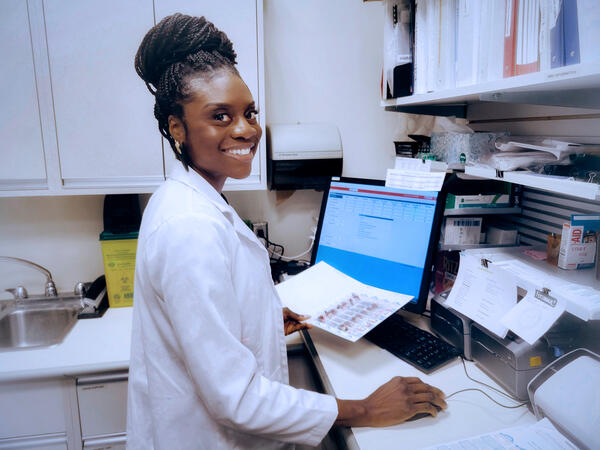 Pharmacist Nneke Ezurike in front of pharmacy counter