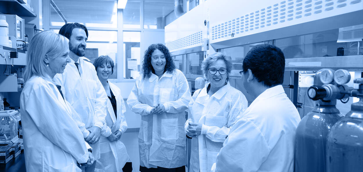 Dean Lisa Dolovich (center) and MPP Martin (second from right) join scientists at U of T's Leslie Dan Faculty of Pharmacy to learn about a new self-driving lab led by Professor Christine Allen (left) to test different combinations of materials and develop optimal drug formulations.